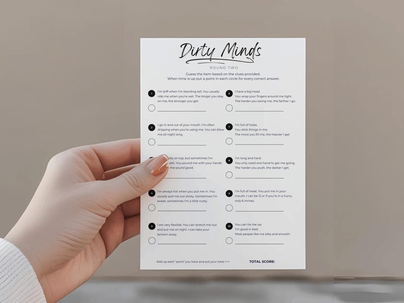 May include: A white card with the title "Dirty Minds" and clues for a game. The card is held by a hand with manicured nails. The game card has a list of clues and circles for answers.