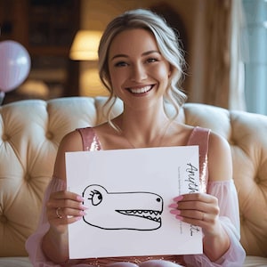 May include: A woman holding a white paper with a black cartoon alligator drawing. The paper also has the word "Anyth" and other text. The woman is wearing a pink dress and is smiling.