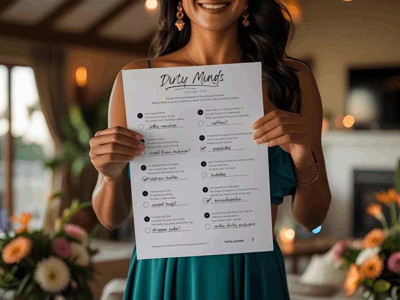 May include: A person holds a white sheet of paper with the title "Dirty Minds" and a list of fill-in-the-blank questions. The paper has a total score of 3 at the bottom. The person is wearing a teal dress.