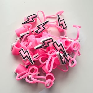 May include: A pile of pink silicone bottle stoppers with a black lightning bolt design.