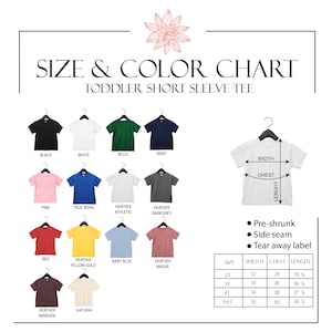 May include: Size and color chart for toddler short sleeve tees. The chart displays various tee colors, including black, white, pink, and red. Measurements are provided in inches for width, chest, and length. Features include pre-shrunk fabric, side seams, and a tear-away label.