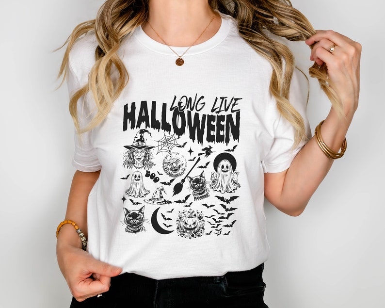 May include: White t-shirt with a black graphic print that says "Long Live Halloween" and features a witch, ghosts, bats, a cat, a crescent moon, and a pumpkin.
