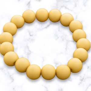 May include: A yellow beaded bracelet with a circle shape.