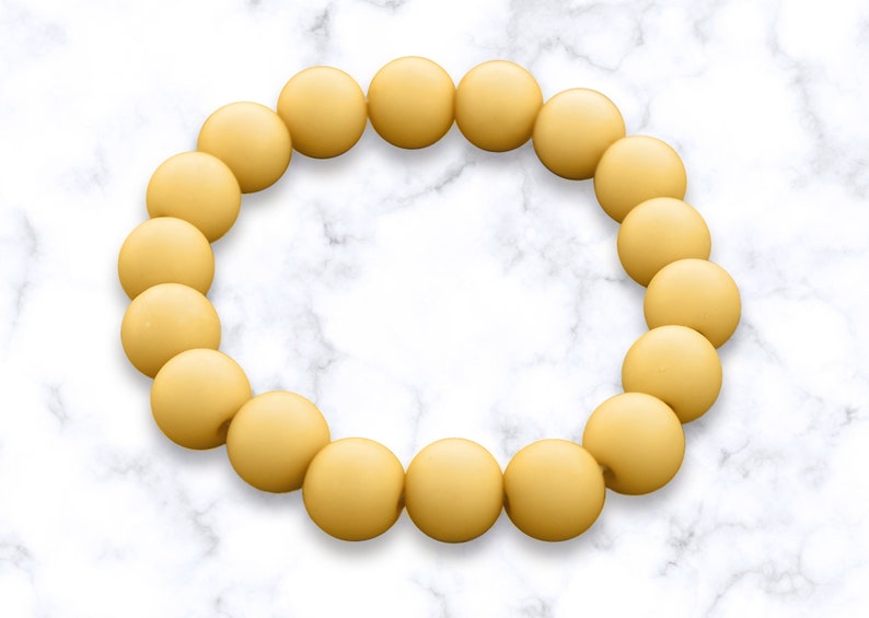 May include: A yellow beaded bracelet with a circle shape.