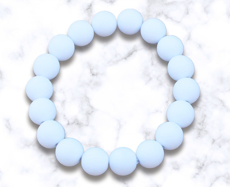 May include: A light blue silicone bracelet with round beads.