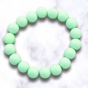 May include: A light green silicone bracelet with round beads.