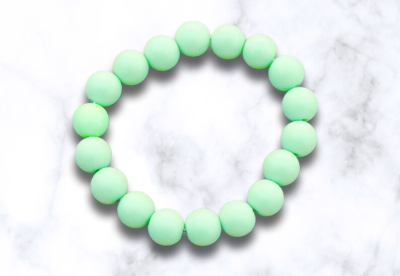 May include: A light green silicone bracelet with round beads.