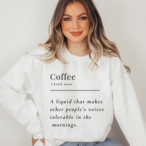 May include: White sweatshirt with the word "Coffee" and a definition: "A liquid that makes other people's voices tolerable in the mornings."
