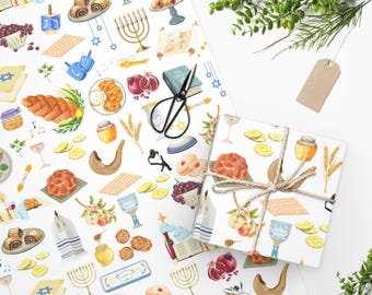 Puede incluir: Papel de regalo blanco con un patrón repetitivo de símbolos de festividades judías, incluyendo una menorá, un shofar, una jalá y una granada. El papel está envuelto alrededor de una caja de regalo con una cinta marrón.