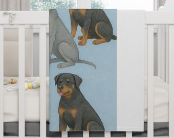 Puede incluir: Una manta para bebé con ilustraciones de tres perros en posición sentada. Los perros están representados en tonos grises, negros y marrones sobre un fondo azul claro. La manta es blanca en el lado derecho.