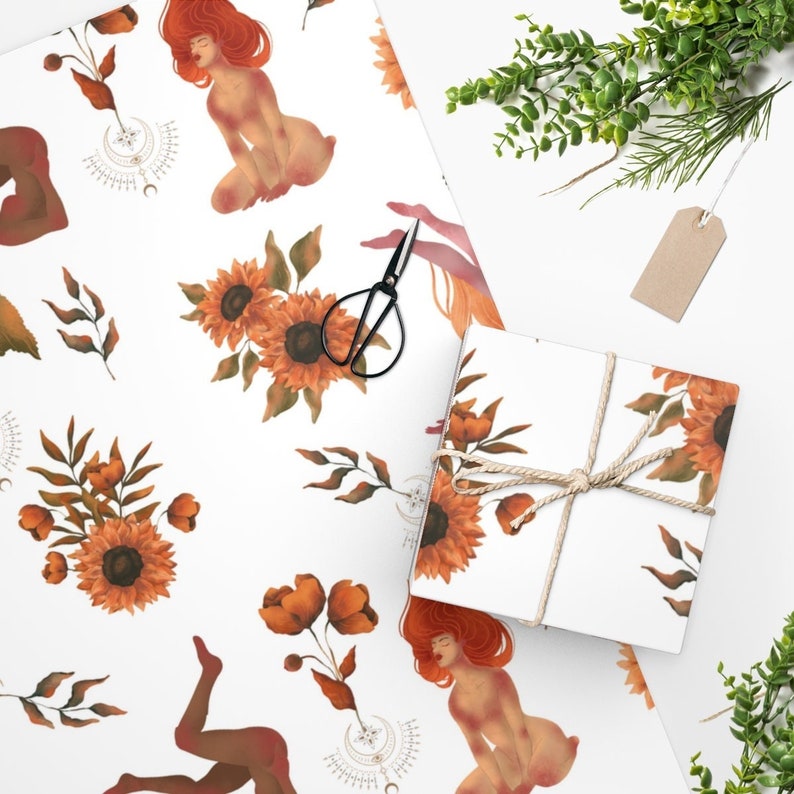 May include: White wrapping paper with a repeating pattern of sunflowers, leaves, and figures. The figures are nude and have red hair. The sunflowers are yellow with orange centers. The leaves are green.