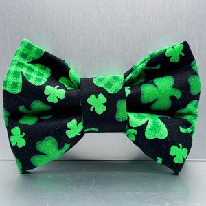 May include: A black bow tie with a green shamrock pattern.