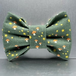 May include: A green bow tie with a mushroom and star pattern.