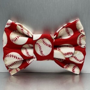 May include: Red bow tie with a white baseball pattern.