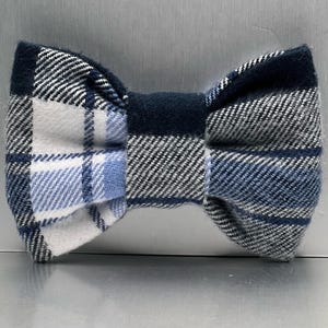 May include: A blue and white plaid bow tie. The bow tie is made from a soft, comfortable fabric and has a classic design.