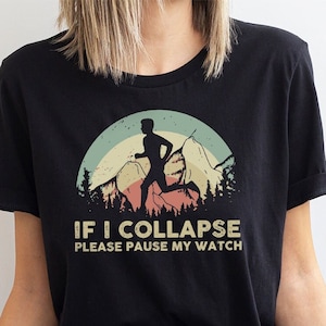 May include: Black t-shirt with a vintage-style graphic of a runner in a forest scene. The text reads "If I Collapse Please Pause My Watch".