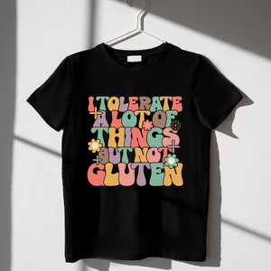 May include: Black t-shirt with a colorful retro-style graphic that says "I tolerate a lot of things but not gluten".