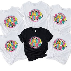 May include: Set of six white t-shirts with a black t-shirt in the centre. All shirts feature a colourful graphic with the text "Diagnosistician" in a leopard print circle.