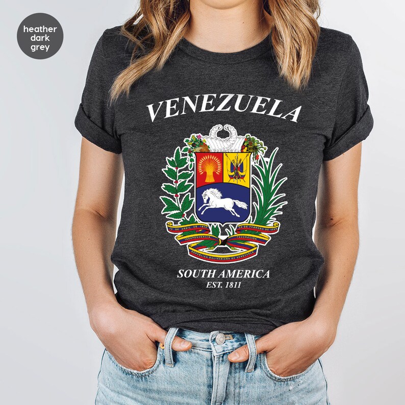 a woman wearing a t - shirt with a coat of arms on it