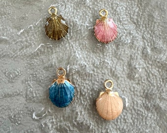 May include: Four gold-tone shell charms with enamel detailing. The shells are in shades of brown, pink, blue, and cream.