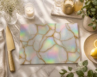 Può includere: Un tagliere rettangolare caratterizzato da una superficie bianca con una finitura olografica iridescente e venature color oro che imitano l'aspetto della pietra crepata. Il tagliere presenta una superficie superiore piatta e liscia di forma rettangolare.