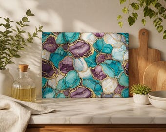 Può includere: Un tagliere rettangolare in vetro caratterizzato da un motivo astratto a inchiostro alcolico con sfumature vorticose di verde acqua, viola intenso e bianco, accentuato da sottili venature dorate metallizzate che delineano ogni forma.