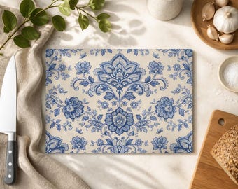 Può includere: Un tagliere rettangolare in vetro caratterizzato da un motivo floreale damascato ripetuto in blu e crema. Il design è composto da intricati motivi botanici blu, tra cui grandi fiori centrali e foglie a volute su uno sfondo color crema.