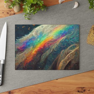 May include: Rectangular cutting board featuring a vibrant, abstract design of a rainbow arcing across a cloudy, textured background. The color palette includes blues, greens, yellows, oranges, and purples. The board is set on a gray surface.