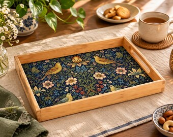 Può includere: Un vassoio da portata rettangolare in legno con manici intagliati, caratterizzato da una base interna blu scuro decorata con un motivo ripetuto di uccelli gialli, fiori chiari e fogliame verde. Il vassoio ha una finitura in legno chiaro naturale.