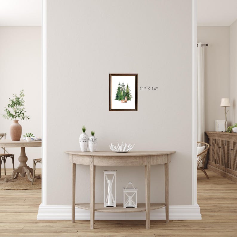 Puede incluir: Una pintura acuarela enmarcada de un grupo de pinos verdes con un ciervo marr&oacute;n en primer plano. El marco es de madera marr&oacute;n y la pintura mide 28 cm x 35,5 cm.