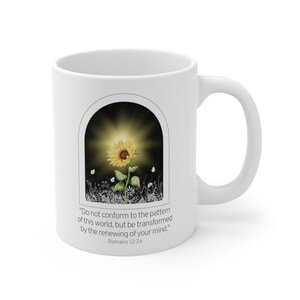 May include: White ceramic mug with a sunflower graphic and the quote "Do not conform to the pattern of this world, but be transformed by the renewing of your mind." Romans 12:2a