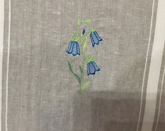 Fiore di campanula su strofinaccio ricamato in lino 100%.