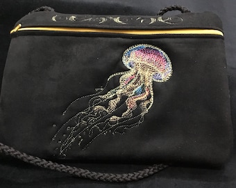 NUOVO FORMATO PIÙ GRANDE! 9 1/2” x 7”. Borsa con cerniera ricamata con Medusa Iridescente. Borsa con cerniera foderata e tracolla.