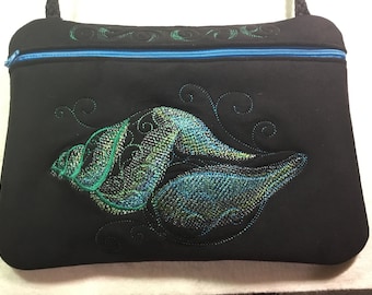 NUOVA TAGLIA PIÙ GRANDE! 9 1/2” x 7”. Borsa con cerniera ricamata conchiglia acquamarina. Borsa foderata con cerniera e tracolla.