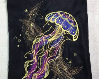 NUOVA DIMENSIONE VERTICALE! Borsa con medusa iridescente ricamata da 9 1/2" x 6 1/2" su finta pelle scamosciata nera. Borsa foderata con cerniera e tracolla.