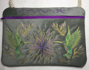 NUOVA TAGLIA PIÙ GRANDE! 9 1/2” x 7”. Borsa con cerniera ricamata elegante colibrì su finta pelle scamosciata grigia. Borsa foderata con cerniera e tracolla.