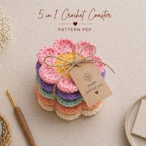 Può includere: Una pila di cinque sottobicchieri all'uncinetto colorati a forma di fiore, legati con spago e un'etichetta con la scritta "made just for you". I sottobicchieri sono rosa, gialli, viola, verdi e pesca. Il testo "5 in 1 Crochet Coaster" è in alto.
