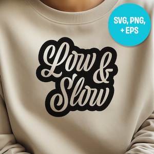 Pode incluir: Uma camisa de moletom bege com um gráfico preto que diz "Low & Slow" em uma fonte estilizada.