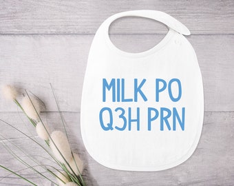 Op de afbeelding: Witte baby-slabbetje met blauwe tekst die "MILK PO Q3H PRN" zegt.