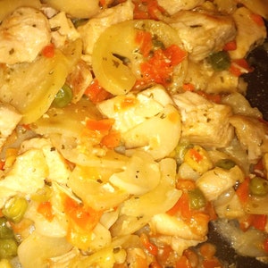 K&ouml;nnte beinhalten: Nahaufnahme eines Gerichts mit H&uuml;hnchen und Kartoffeln mit Karotten, Erbsen und roten Paprikaschoten. Das Gericht ist in einer cremigen Sauce gekocht und sieht k&ouml;stlich aus.