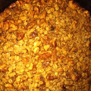 May include: A close-up of a baked oatmeal dish with walnuts. The oatmeal is golden brown and the walnuts are scattered throughout the dish.