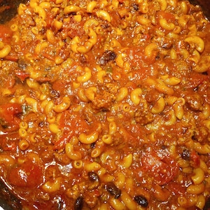 K&ouml;nnte beinhalten: Nahaufnahme eines Topfes mit Makkaroni und K&auml;se mit Hackfleisch und Tomatensauce. Die Makkaroni sind al dente gekocht und die Sauce ist dick und reichhaltig.