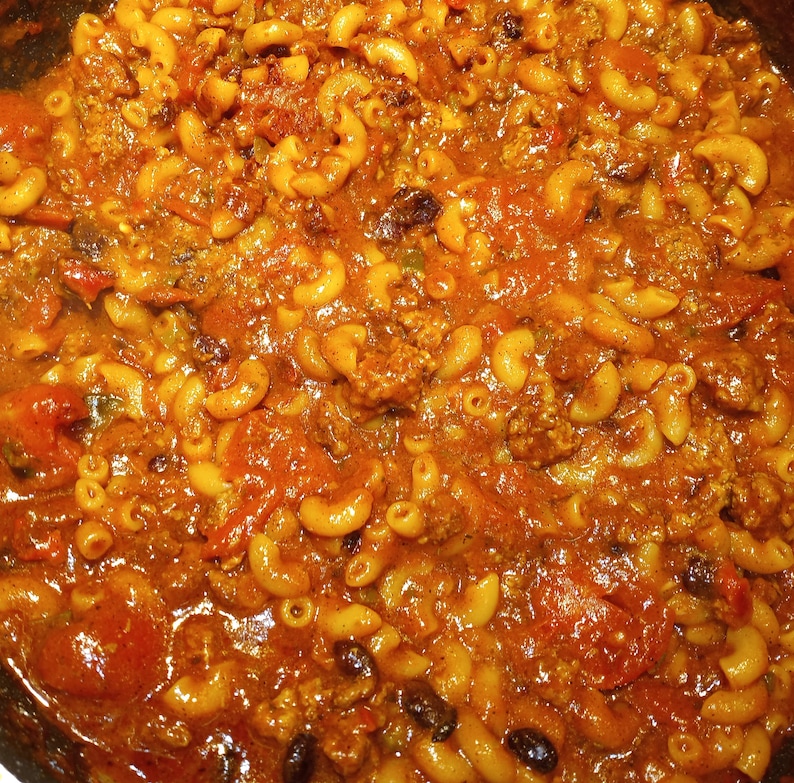 K&ouml;nnte beinhalten: Nahaufnahme eines Topfes mit Makkaroni und K&auml;se mit Hackfleisch und Tomatensauce. Die Makkaroni sind al dente gekocht und die Sauce ist dick und reichhaltig.