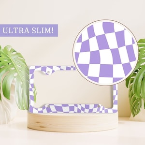 May include: Purple and white checkered license plate frame with the text "ULTRA SLIM!" in white. The frame is made of metal and has a wavy checkered pattern.
