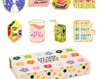May include: A set of 9 enamel pins in a box with a floral design. The pins feature positive messages for teachers, including "Stay Curious", "It's Okay to Make Mistakes", "You Matter", "Be Kind", "Be Brave", "Be Silly", "Be Honest", "Be Happy", and "Be You".