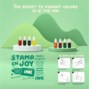 May include: A set of six colorful ink bottles for stamping. The bottles are labeled "STAMP EN JOY" and feature the text "People Safe Non Toxic Water Based Premium Quality! Ink". The bottles are arranged on a white platform with a green background.