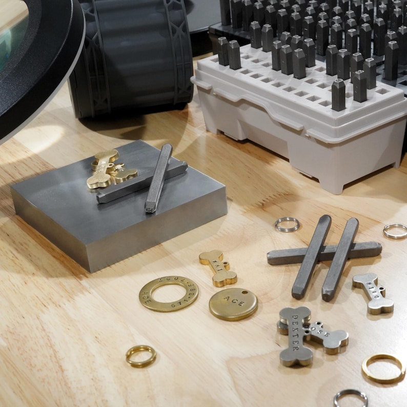 Hand stamping process for custom dog tags for pets, engraved dog tags personalized in workshop