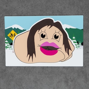May include: A rectangular sticker featuring a cartoon character with dark brown hair, large eyes, and bright pink lips. The character is set against a snowy mountain landscape with a yellow school crossing sign visible in the background.