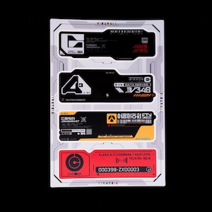 Puede incluir: Una hoja de pegatinas rectangular que presenta cuatro etiquetas distintas con diseños industriales futuristas. Las etiquetas incluyen fondos negros, amarillos y rojos con texto blanco, códigos de barras y símbolos técnicos, incluyendo el texto VIZERALL.