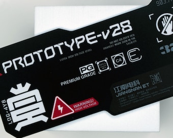 May include: A black rectangular label with white text, including "PROTOTYPE-V28" and "WARNING! HIGH VOLTAGE". The label also features various symbols and the text "PREMIUM GRADE".